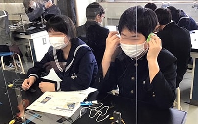 Students listening to music with the earphones they made