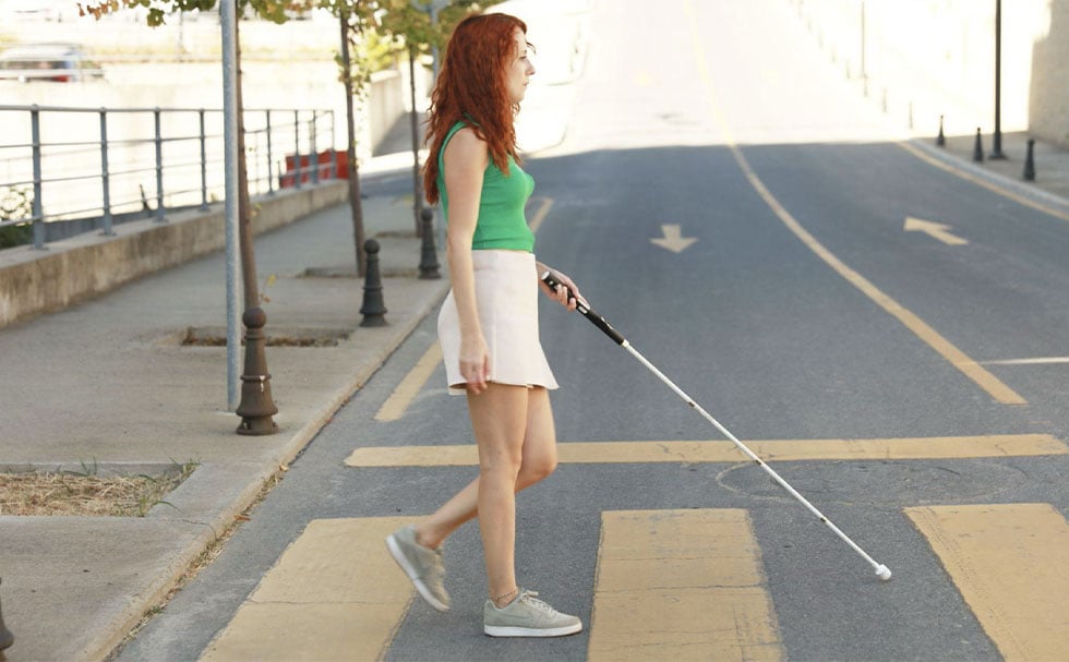 Smart Cane 2を持って横断歩道を歩く人